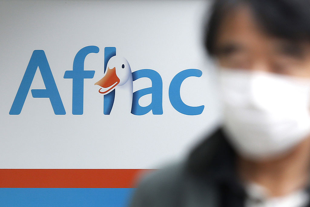 In this photo illustration the Aflac logo of an US insurance company is seen on a smartphone and a pc screen.