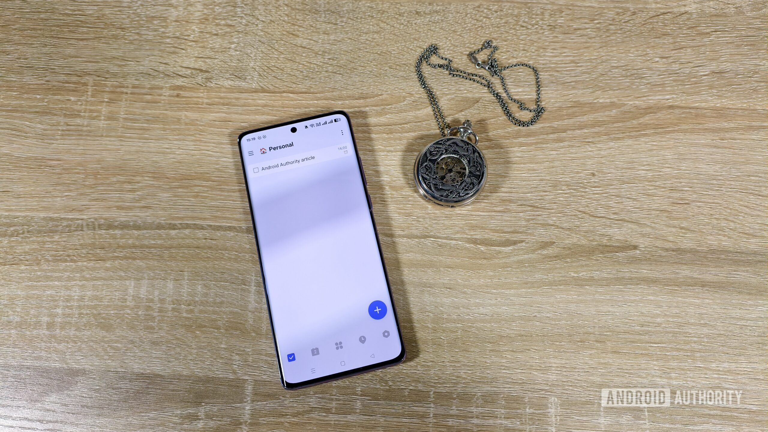 a task in the ticktick app on a smartphone next to a pocket watch