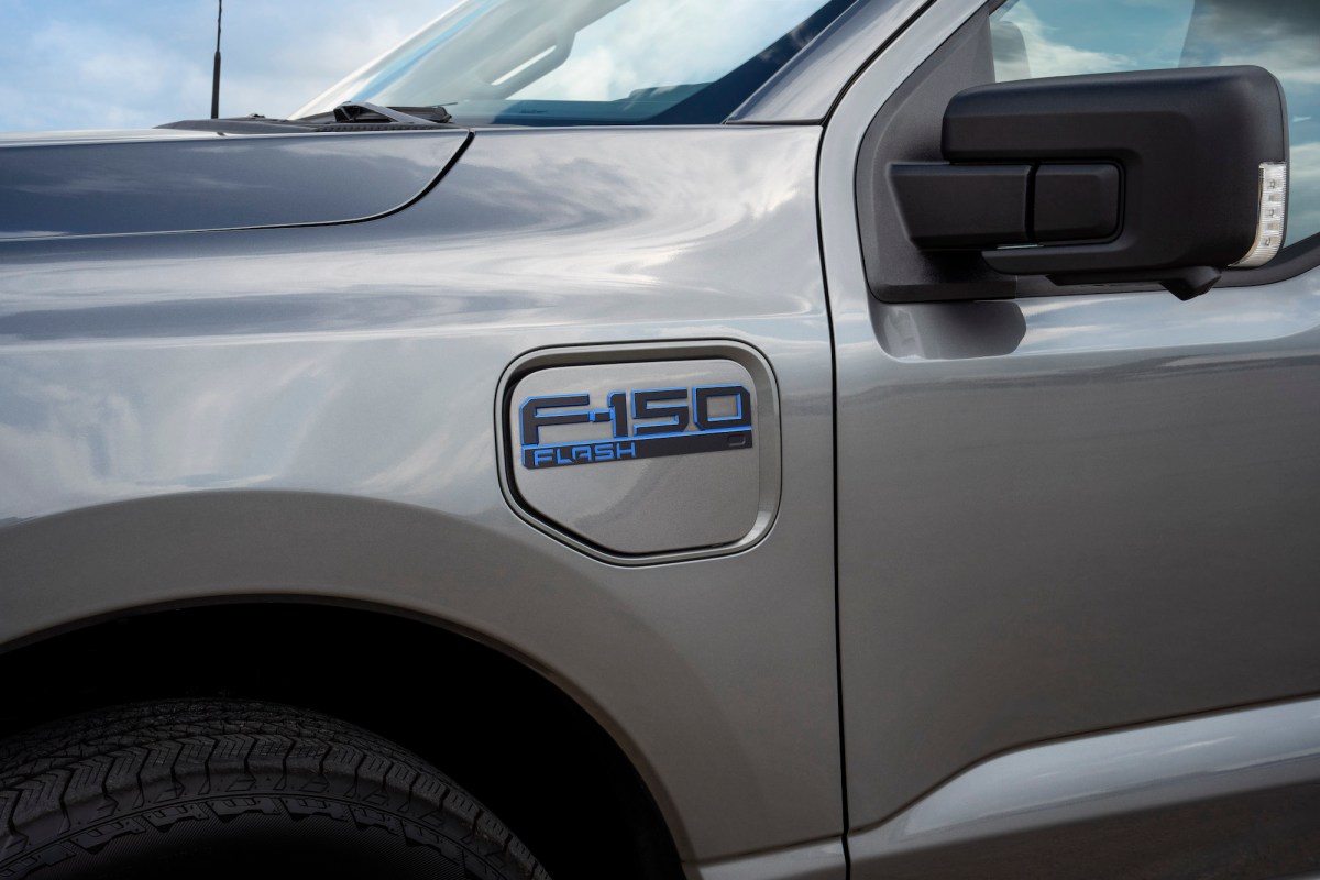 A close up of a gray Ford F-150 electric pickup truck showing a new badge called "Flash."