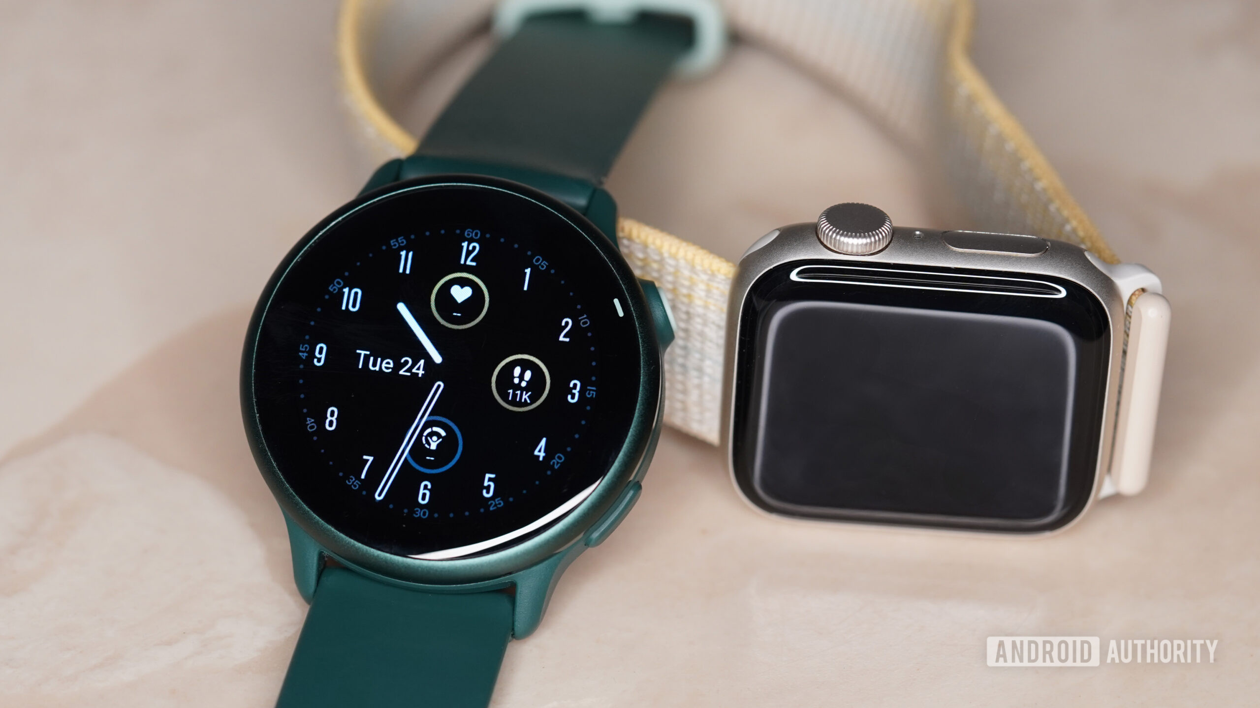 A Garmin Vivoactive 6 rests in front of an Apple Watch SE 2.