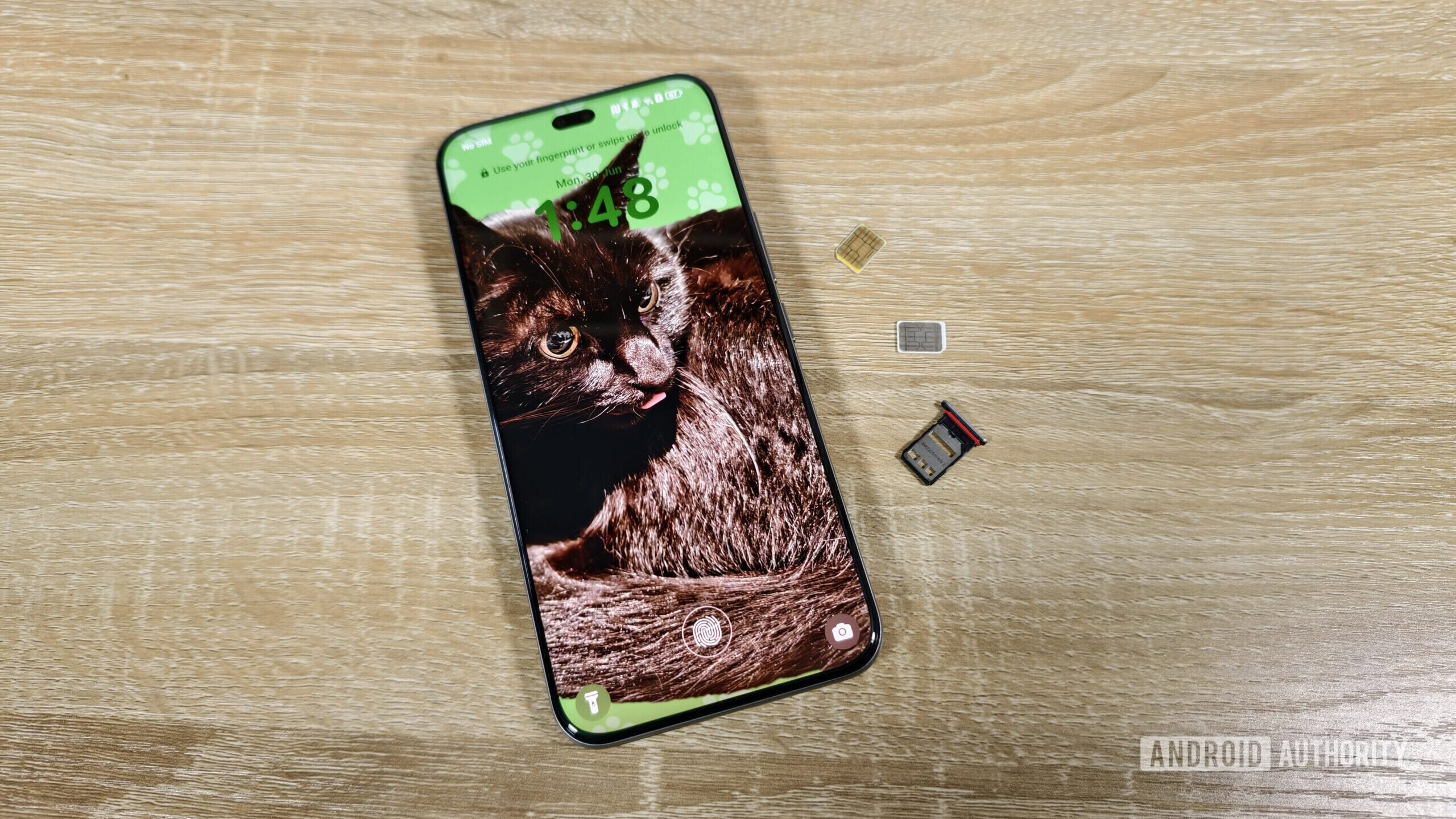 a smartphone with two sim cards and a sim tray on a table